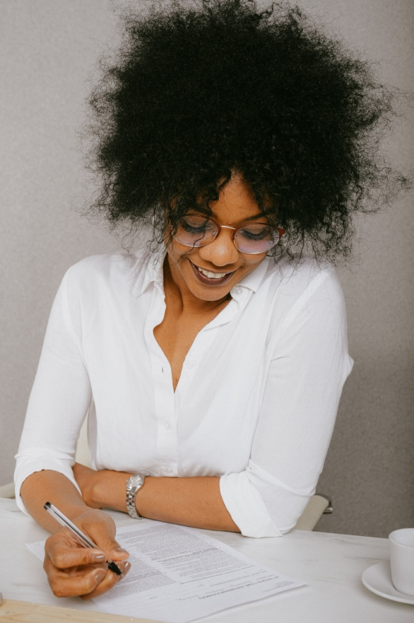 A woman writing on paper with a smile