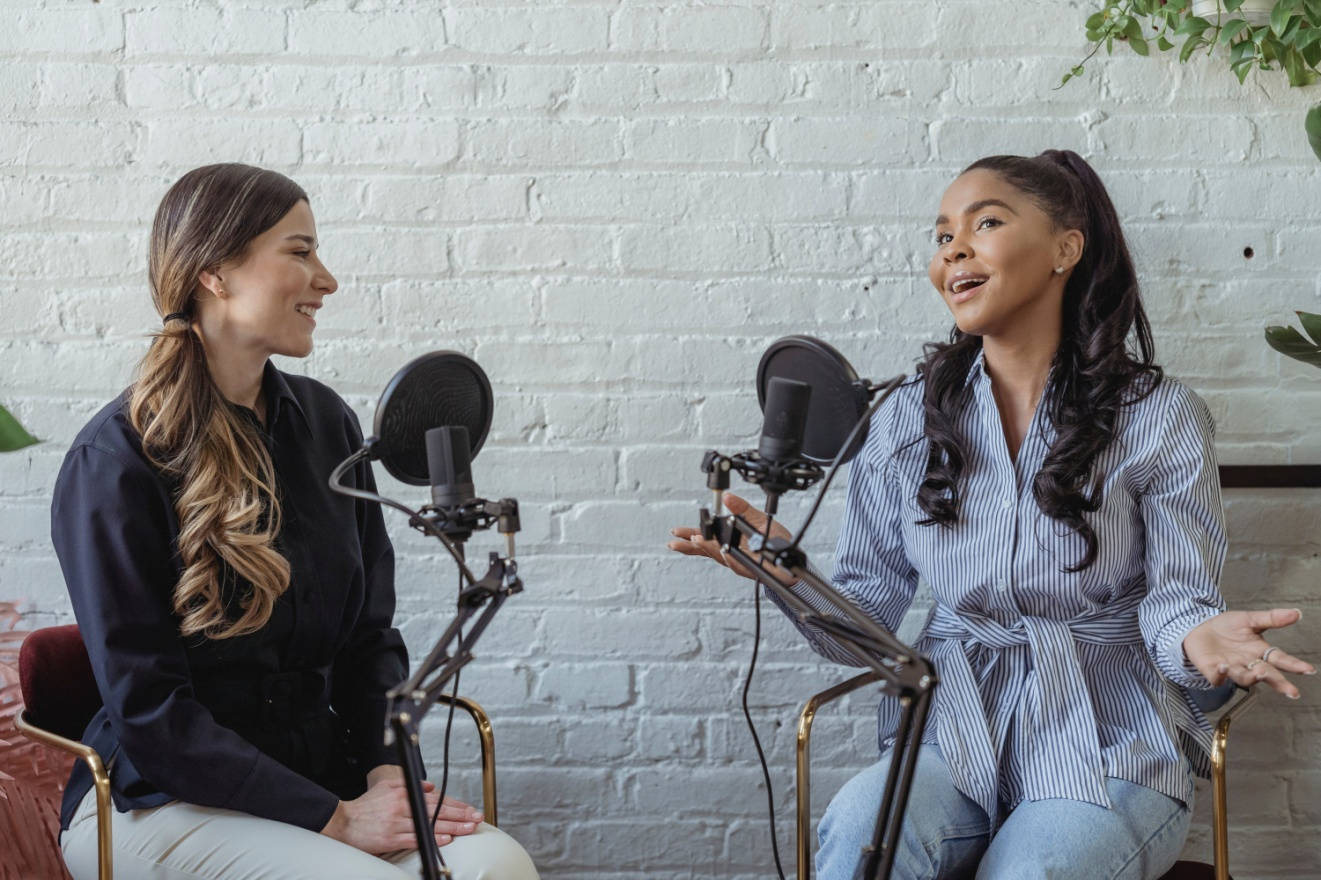 Two women speaking into microphones